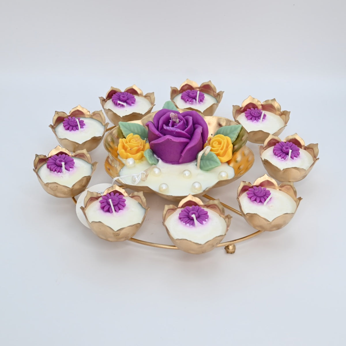 Front view of the Purple Rose Rose Garden Metal Urli Candle Arrangement with purple floral wax details and gold-toned lotus-shaped candle cups.