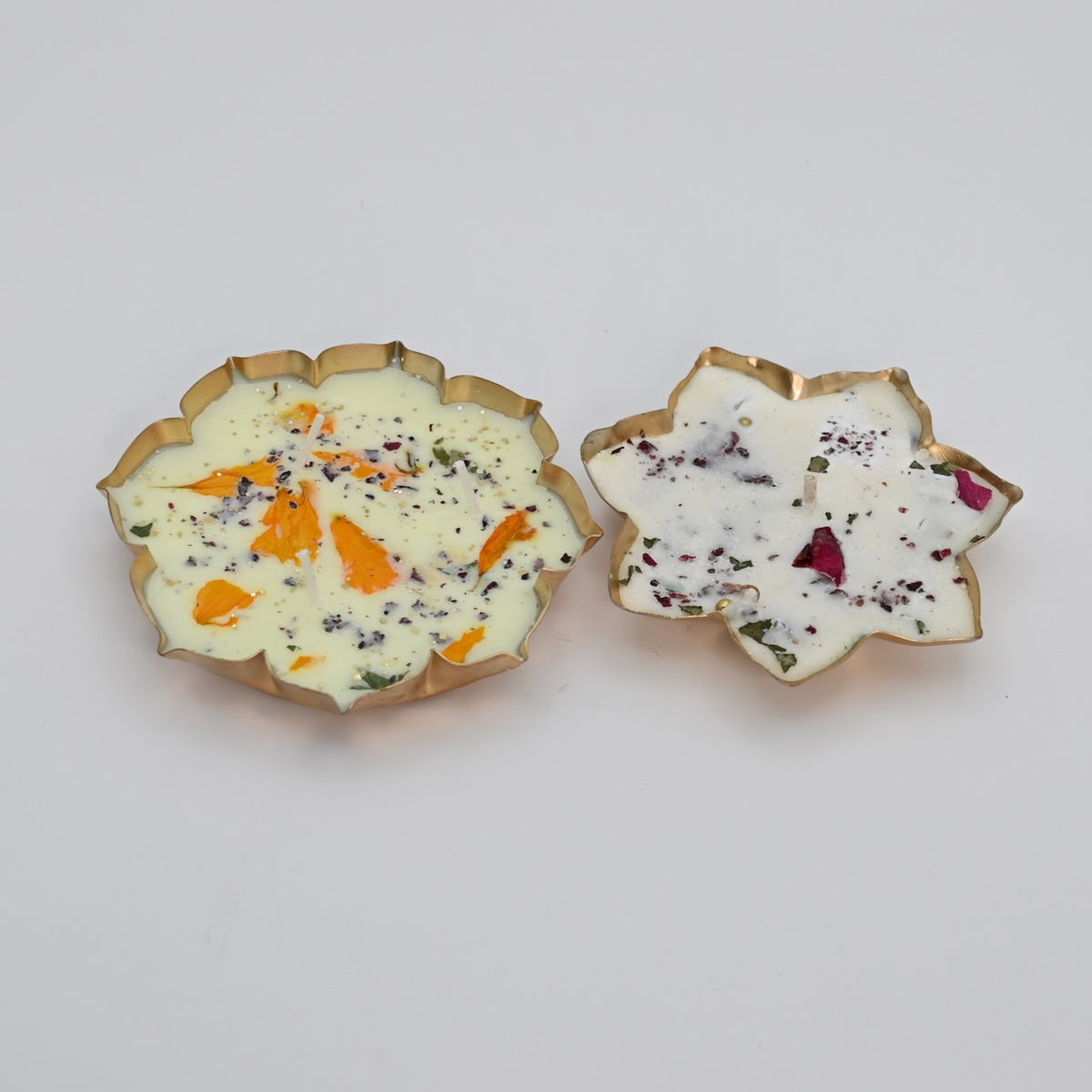 Side view of the Lotus Duo Diya Candle Set showing the raised lotus-shaped metal bowls and candle profiles.