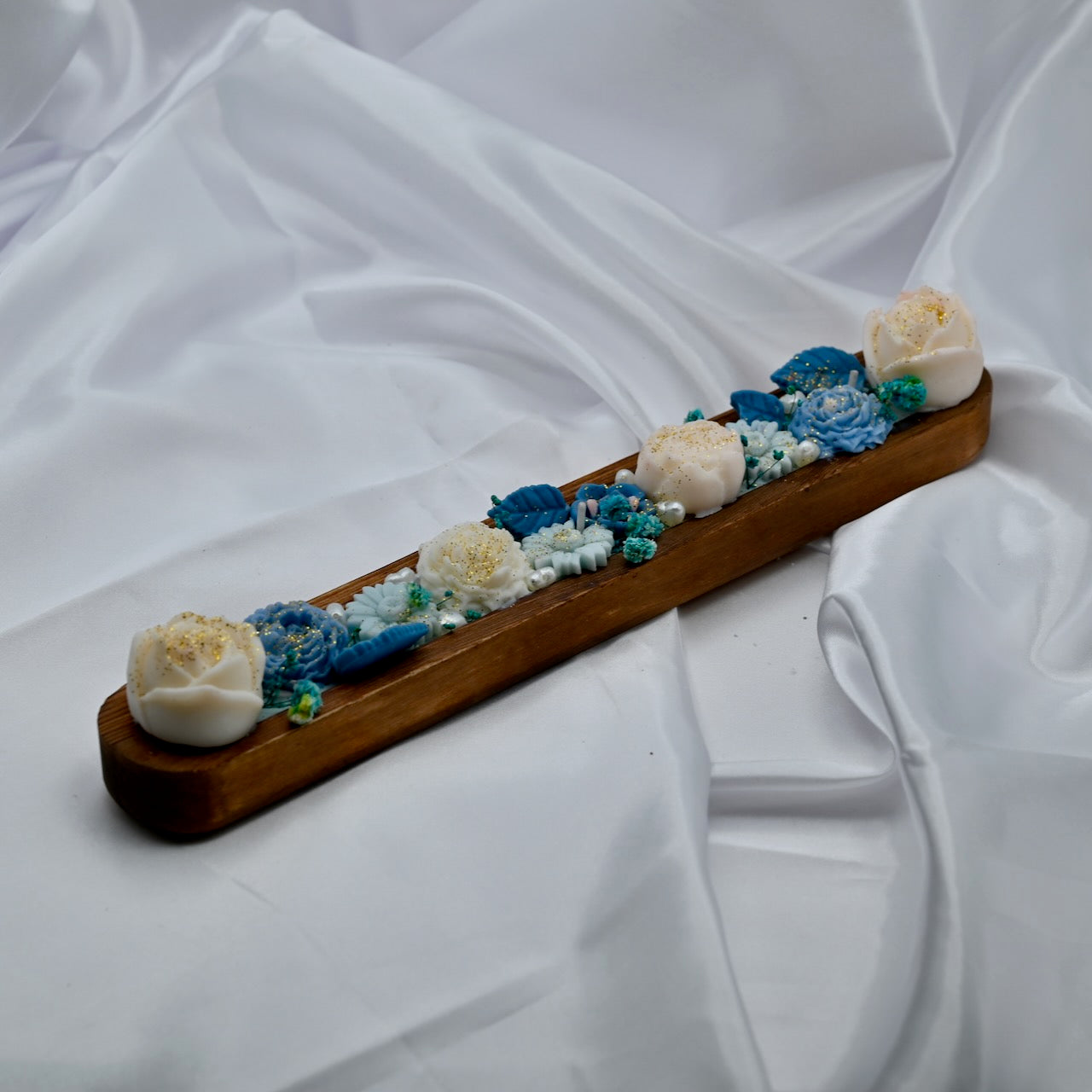 Right view of wooden bowl candle with blue and white floral wax design