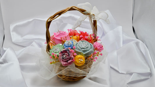 Multiple colorful soy wax flower candle in a wood basket