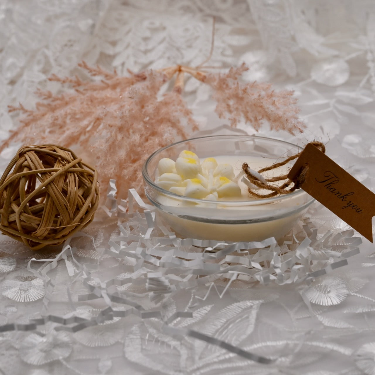 Small glass bowl with decorative items on a textured surface