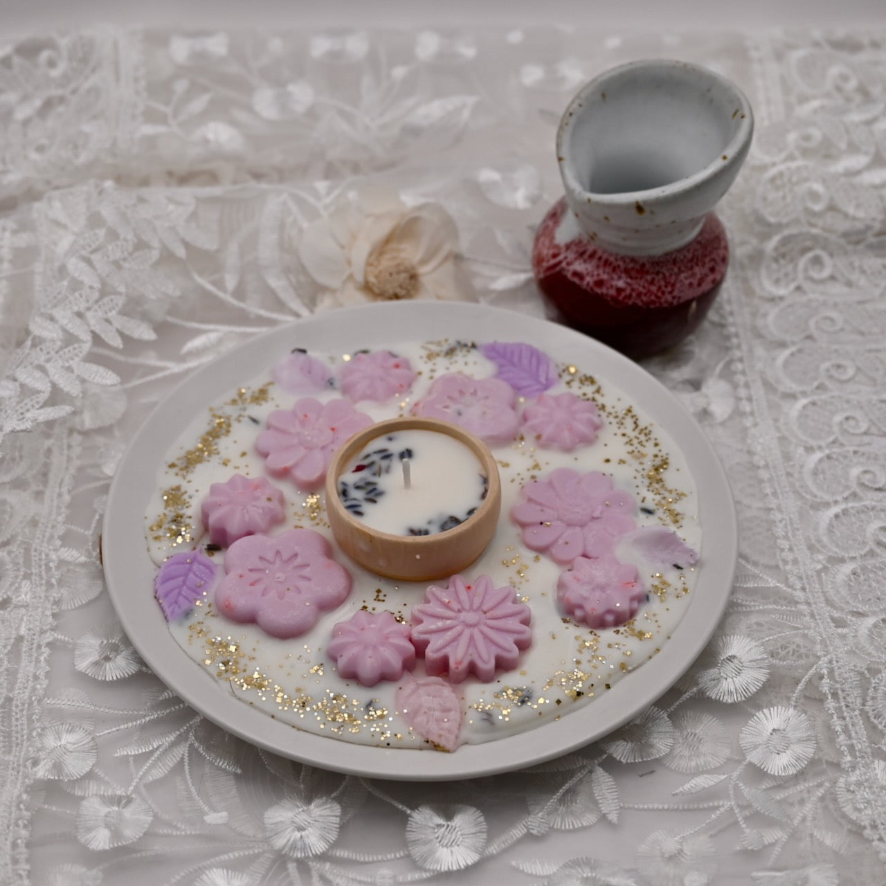 Decorative plate with purple flower-shaped candles on a lace tablecloth.  Diwali decorative plate.