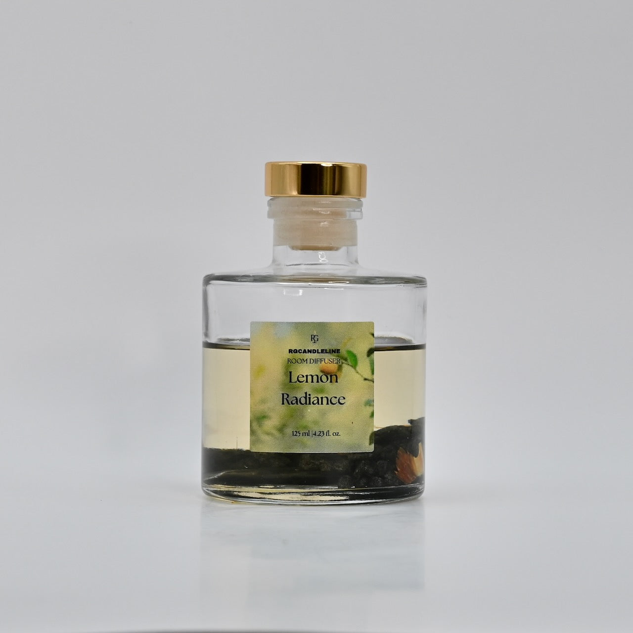 Clear bottle with gold cap and lemon-themed label on a white background