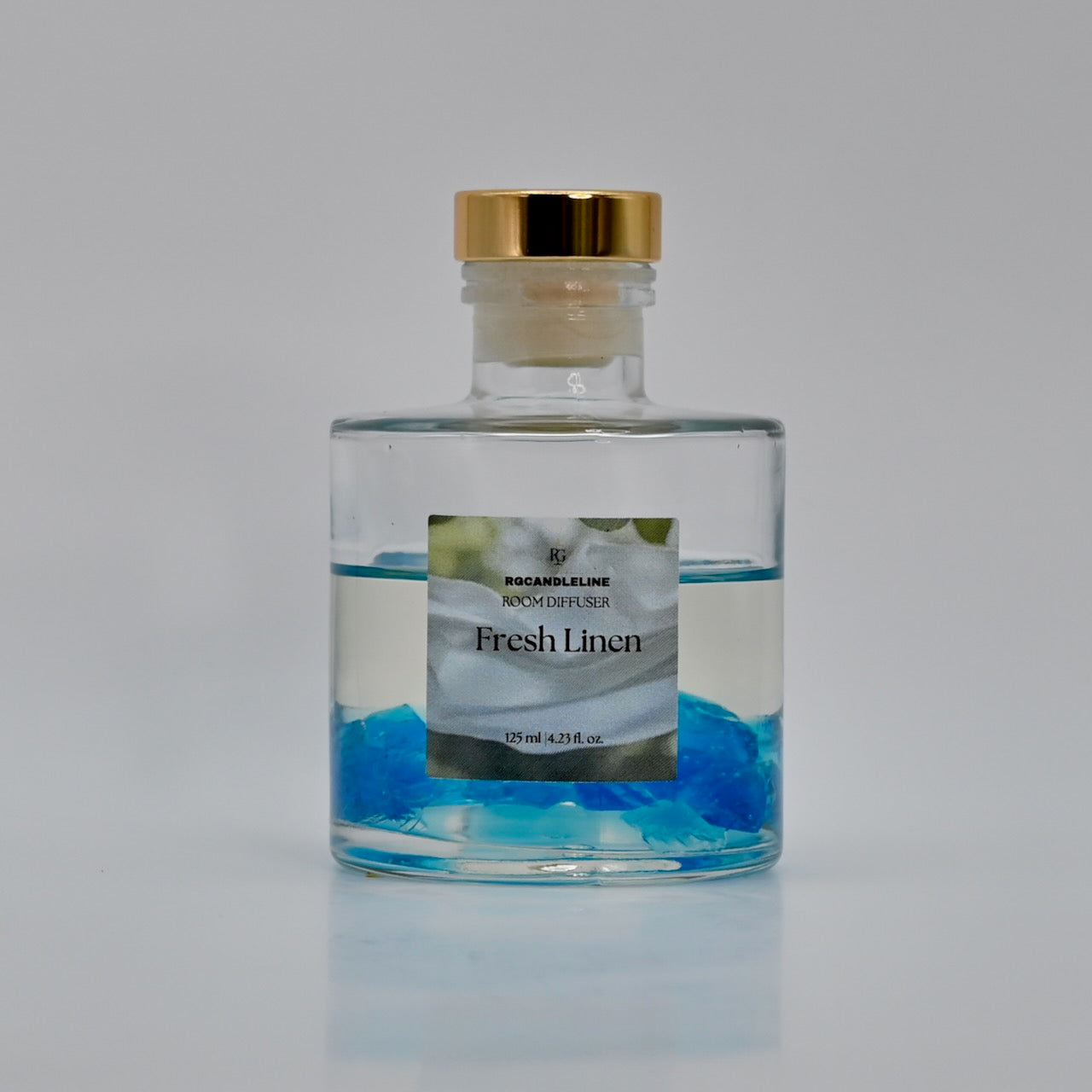 Room diffuser bottle labeled 'Fresh Linen' with a gold cap on a gray background
