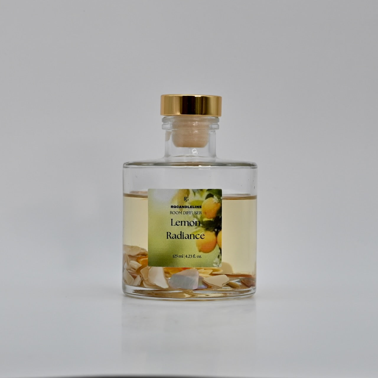 Glass bottle with a gold cap labeled 'Lemon Radiance' on a white background
