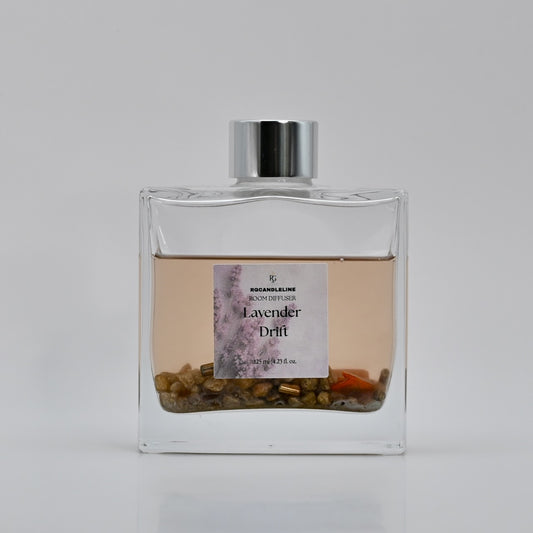 Clear glass diffuser bottle with a silver cap on a light gray background