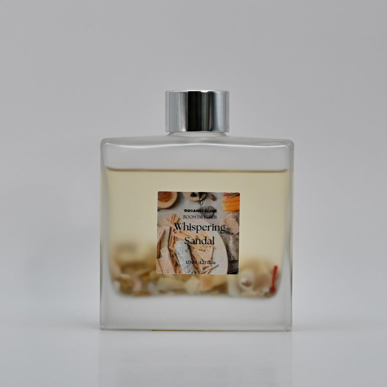 Perfume bottle labeled 'Whispering Sandal' on a gray background