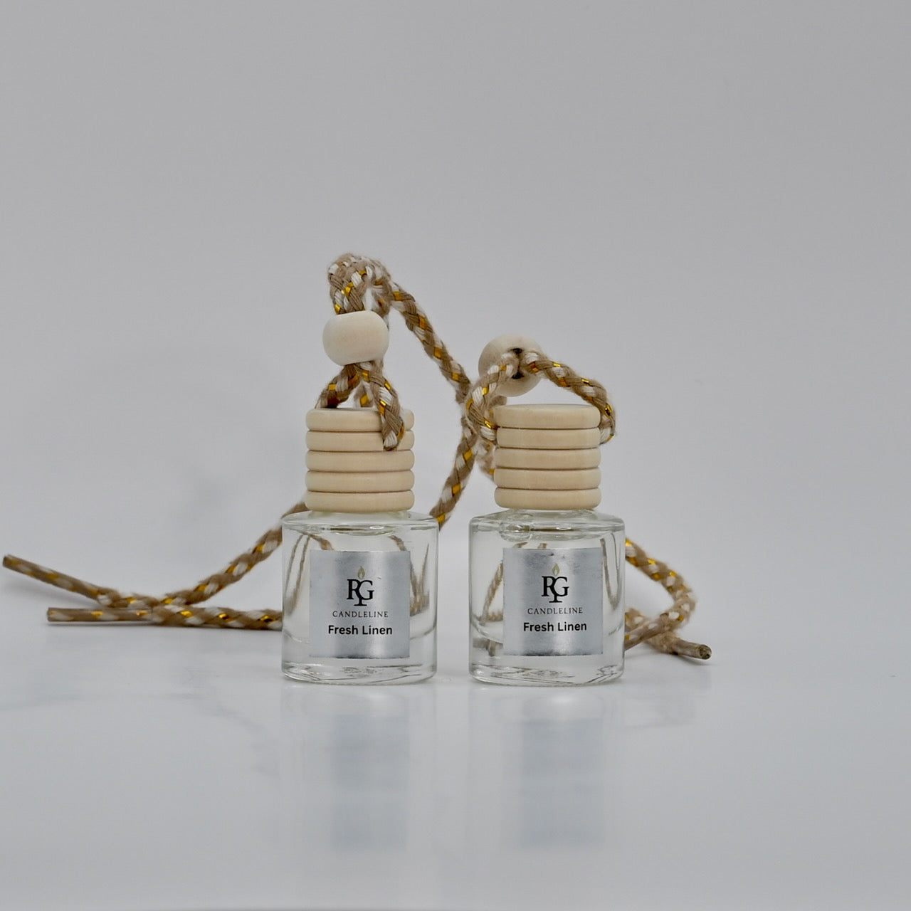 Two small perfume bottles with wooden caps on a light gray background