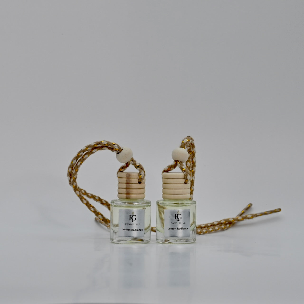 Two small perfume bottles with wooden caps on a gray background