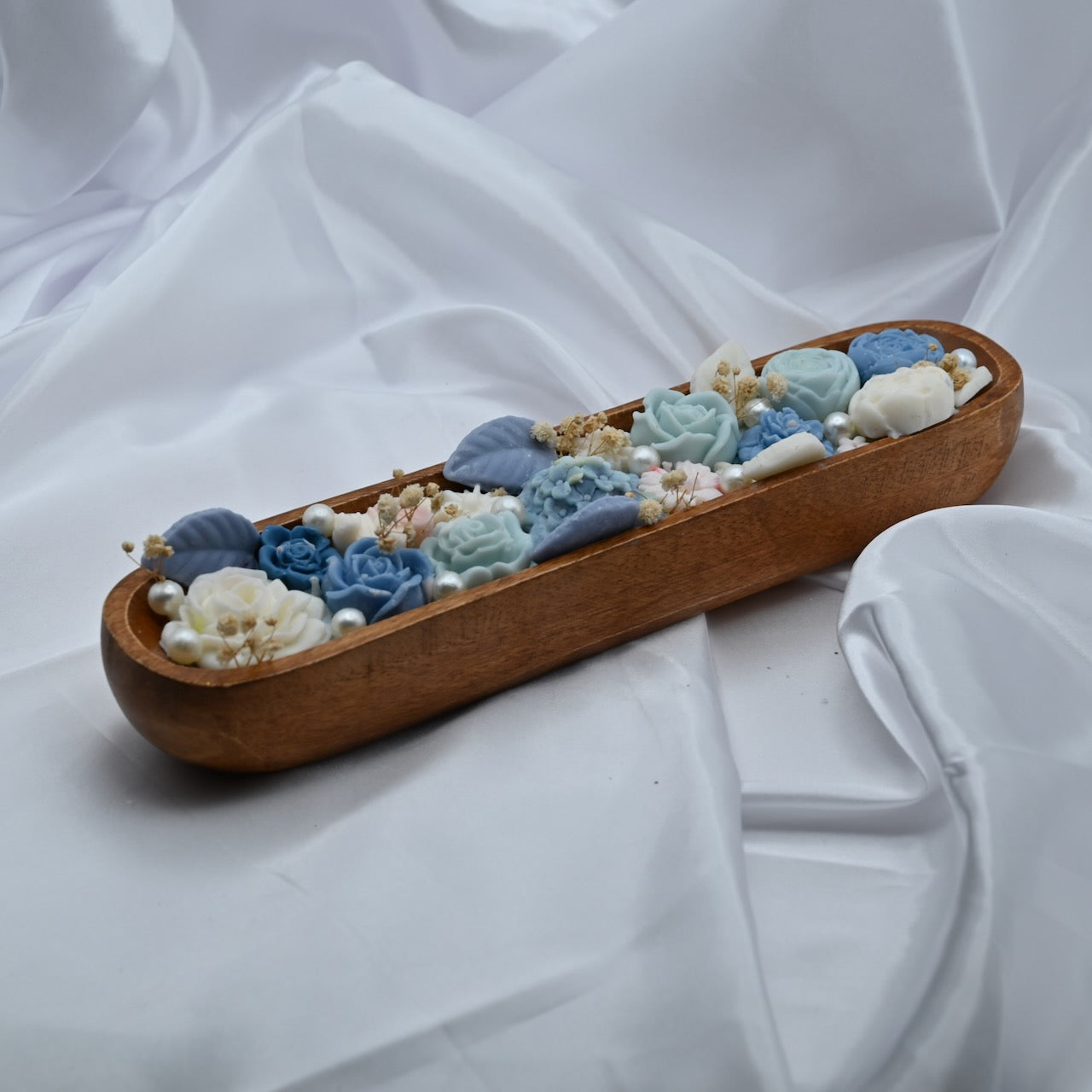 Right view of floral wooden dough bowl candle with blue and ivory wax flowers and pearl accents