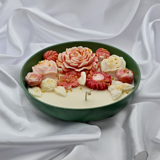 Green bowl candle with pink and blush floral wax design and gold accents