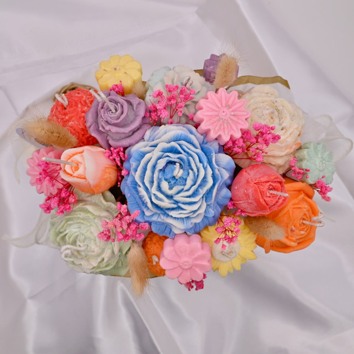 Colorful soy wax flower candle bouquet arrangement on a white background