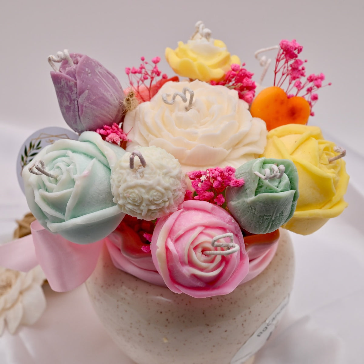 Colorful soy wax flower-shaped candles on a white background