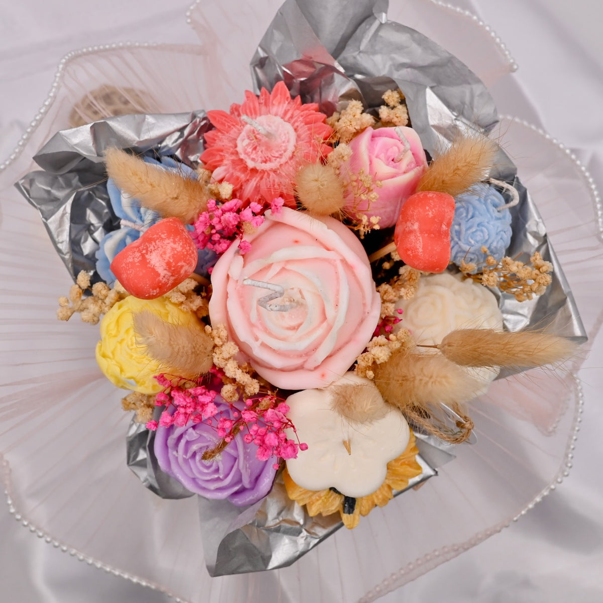Bouquet of colorful soy wax flower candles on a white background