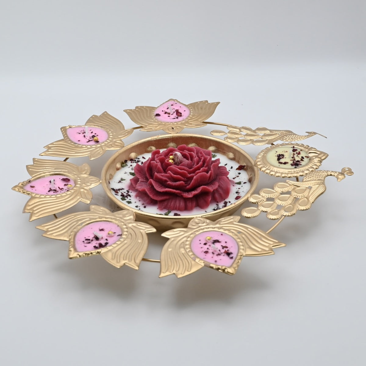 Left view of the Red Peony Peacock Metal Urli Candle Arrangement with gold-toned peacocks and decorative candle holders.