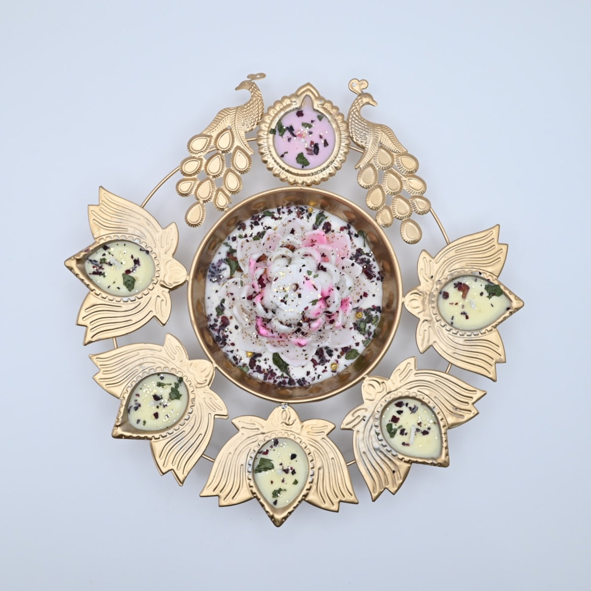 Top view of the White Lotus Peacock Metal Urli Candle Arrangement with gold-toned peacocks, six leaf-shaped candle holders, and a white floral centerpiece.