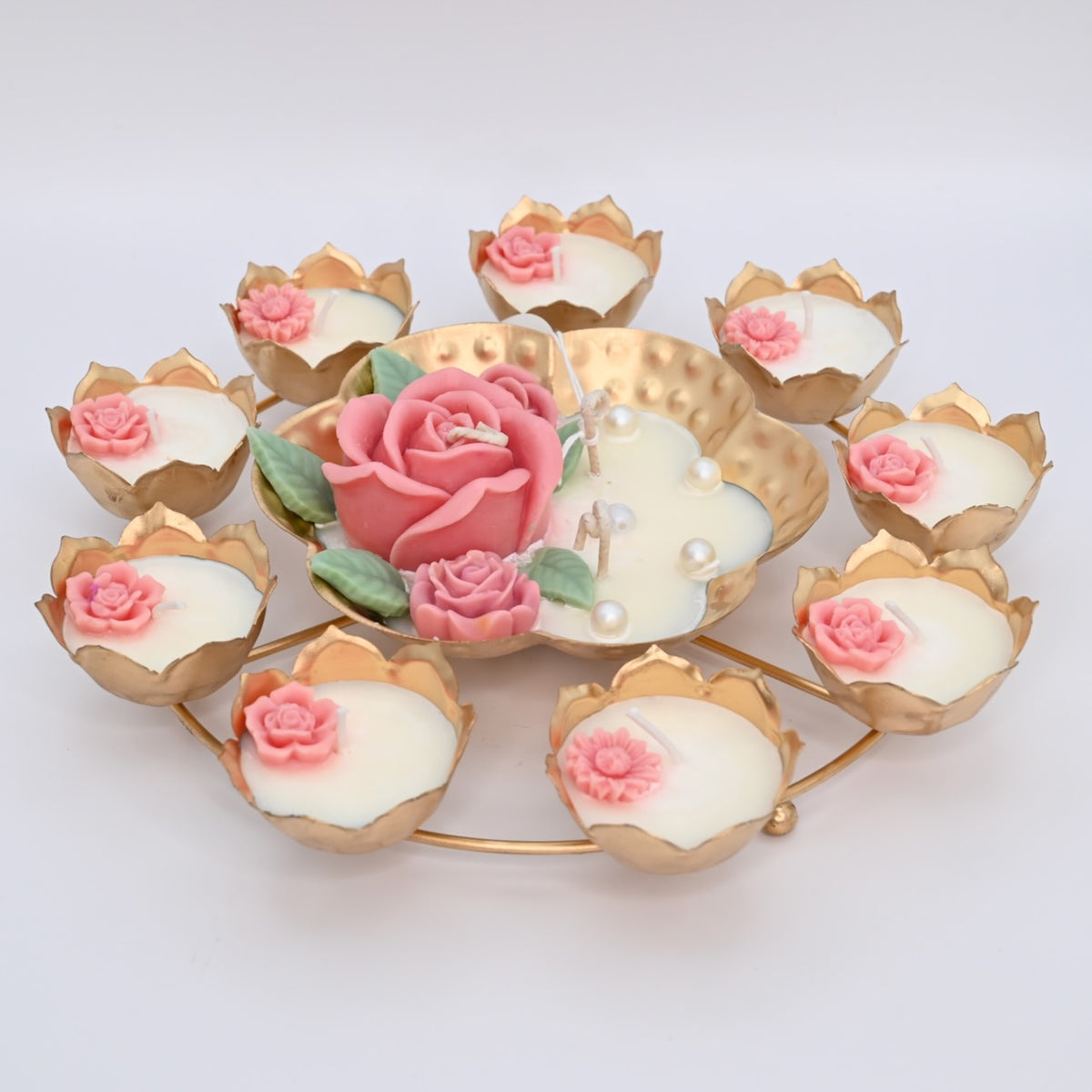 Left view of the Pink Rose Rose Garden Metal Urli Candle Arrangement with a raised pink rose centerpiece and lotus-shaped candle cups.