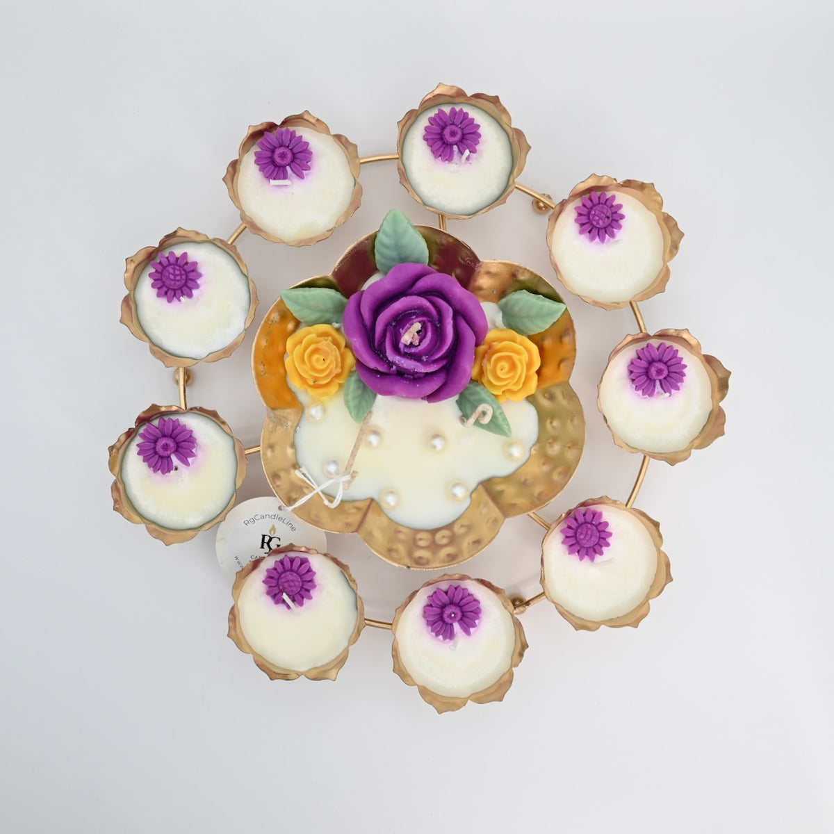 Top view of the Purple Rose Rose Garden Metal Urli Candle Arrangement with purple floral wax details, yellow accent roses, and a gold-toned lotus ring.