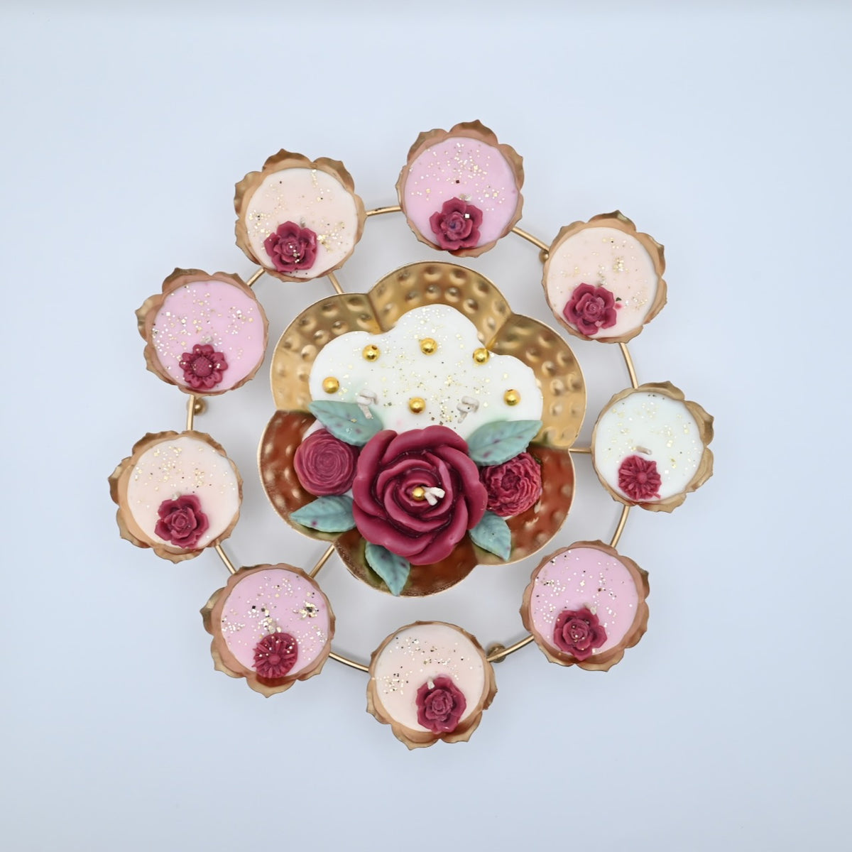 Top view of the Red Rose Rose Garden Metal Urli Candle Arrangement with a gold-toned lotus ring, floral centerpiece, and candle cups.