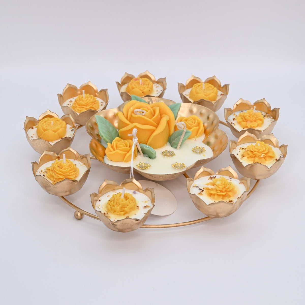 Front view of the Yellow Rose Rose Garden Metal Urli Candle Arrangement with yellow floral wax details and gold-toned metal candle cups.