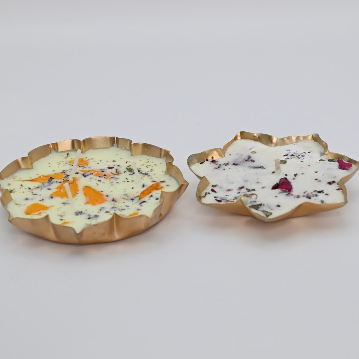 Front view of the Lotus Duo Diya Candle Set with two decorative lotus-shaped metal bowls and floral wax candles.