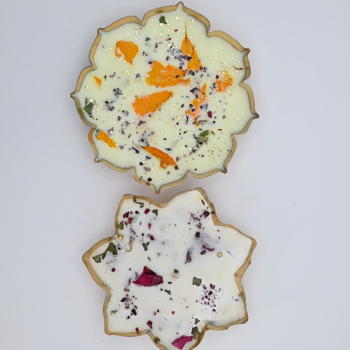 Top view of the Lotus Duo Diya Candle Set showing large and small floral candles in gold-toned lotus-shaped metal bowls.