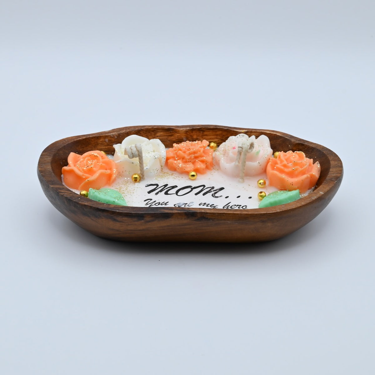 Low front view of the Mom You Are My Hero soy wax candle in an oval wooden tray, showing its floral wax design and two wicks.