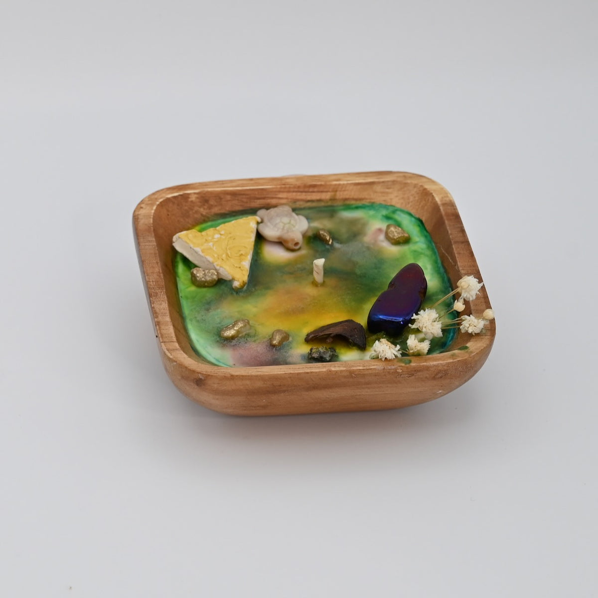 Right view of Ocean Bloom wooden bowl candle with green and yellow wax, crystal accents, and dried flowers
