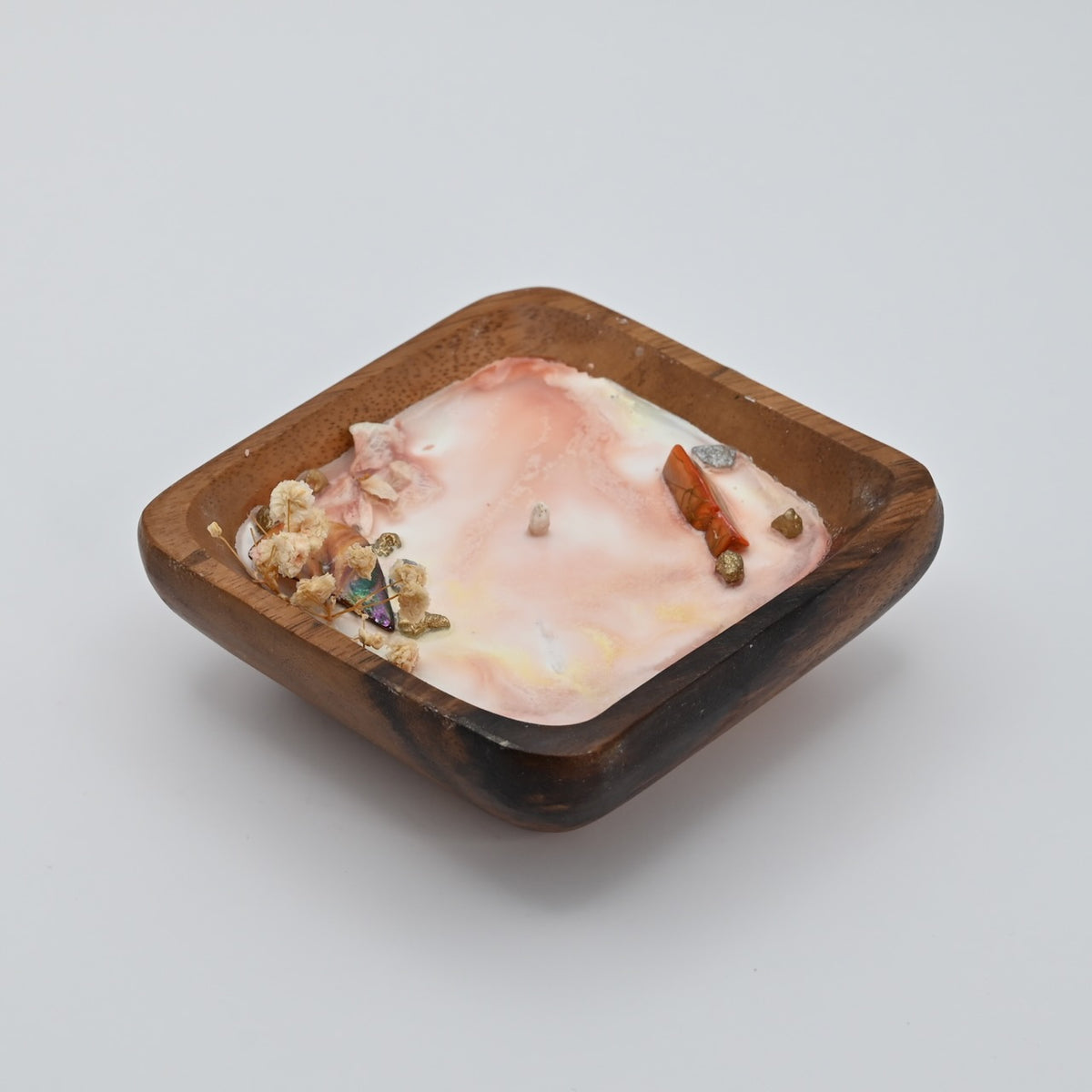 Right view of ocean Bloom wooden bowl candle with pink wax, shell, crystal, and dried flower accents