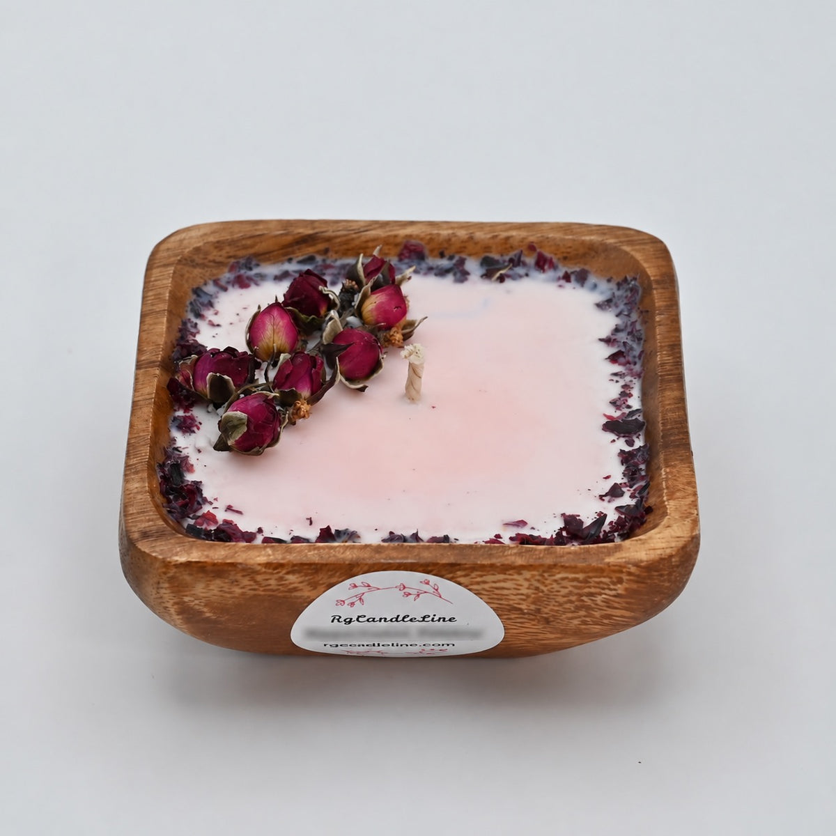 Front view of a 4-inch acacia wood bowl candle with pale wax, dried rosebuds, and a dark floral border.