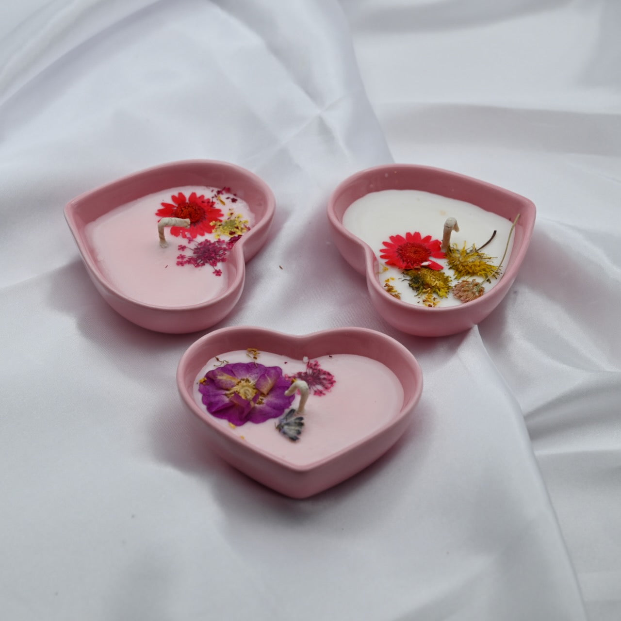 Three mini pink heart-shaped candle with decorative wax detail