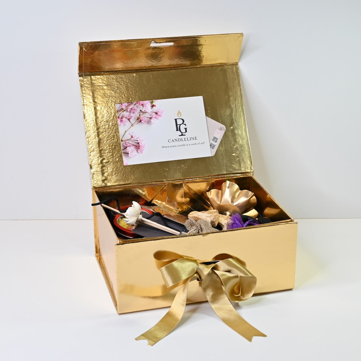 Full view of large gold-finish gift box candle hamper with ribbon