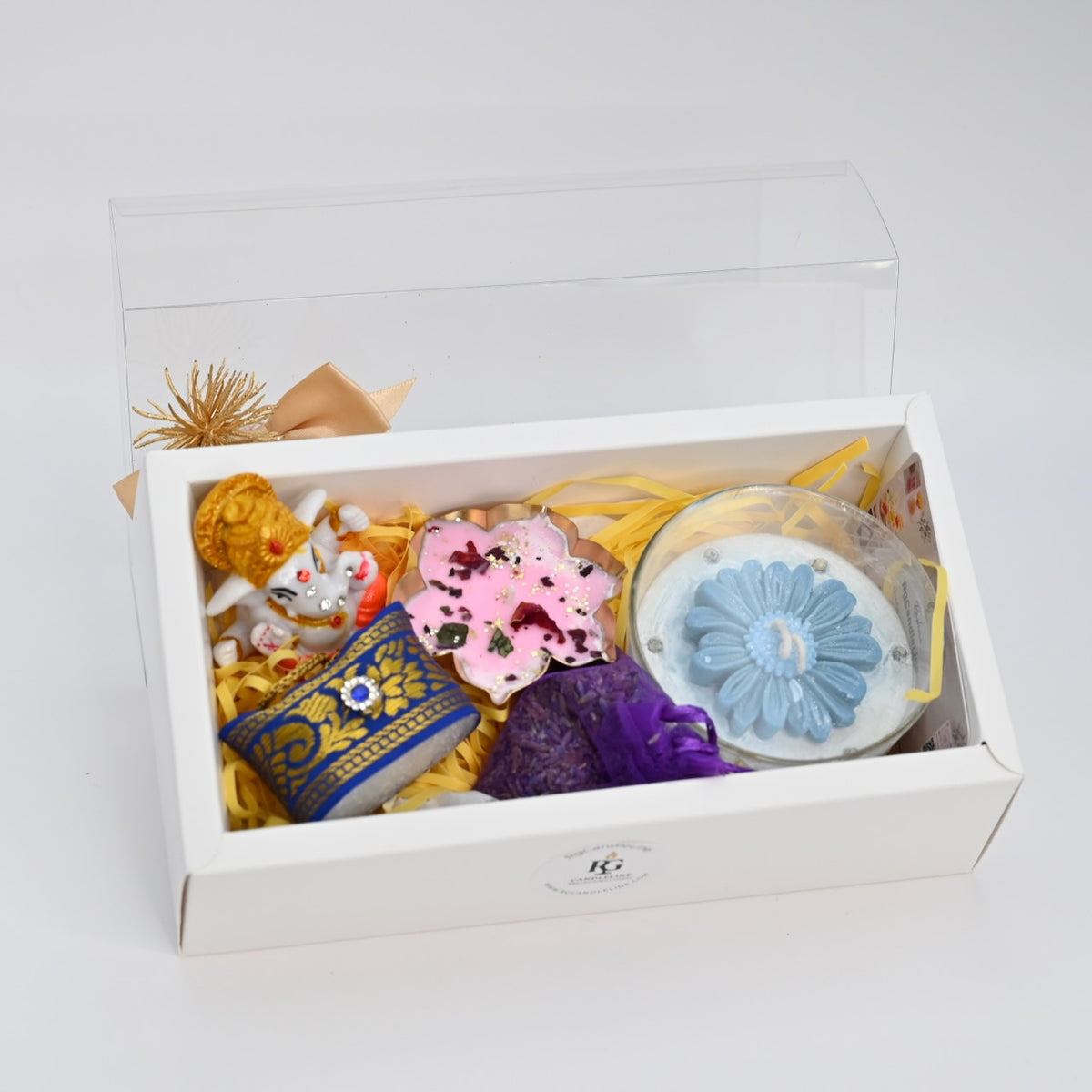Large white gift box with open lid and arranged candle gift hamper contents