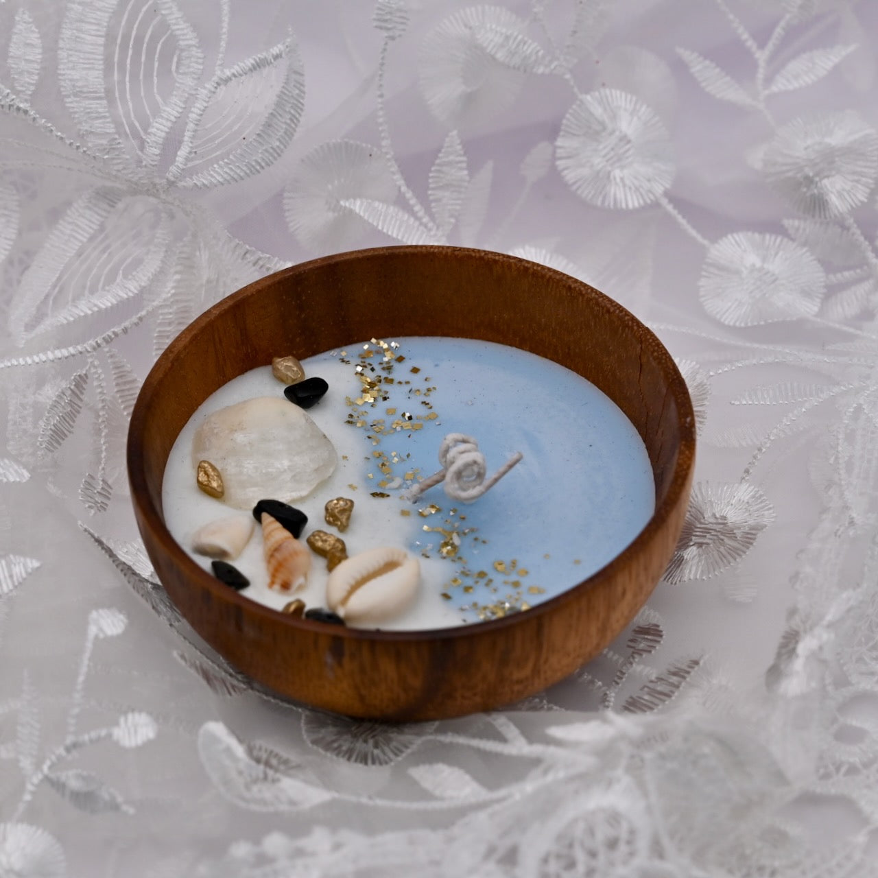 Left view of round acacia wood bowl candle with seashell and starfish wax details