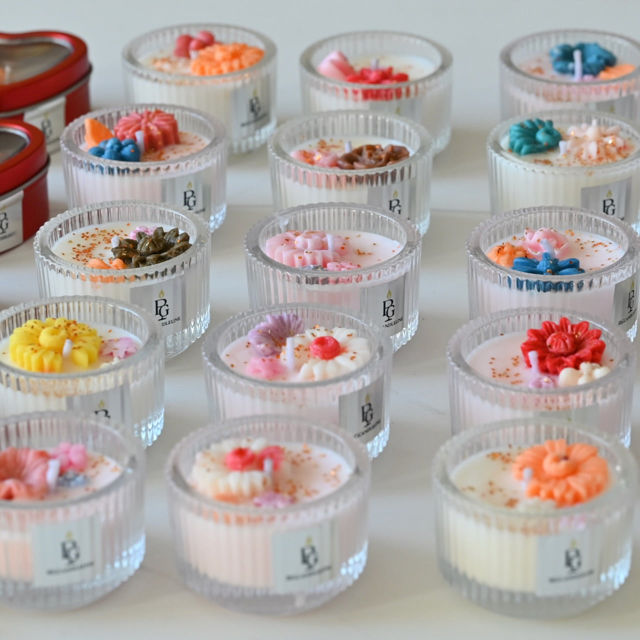 Multiple mini glass candles decorated with colorful flowers on the top