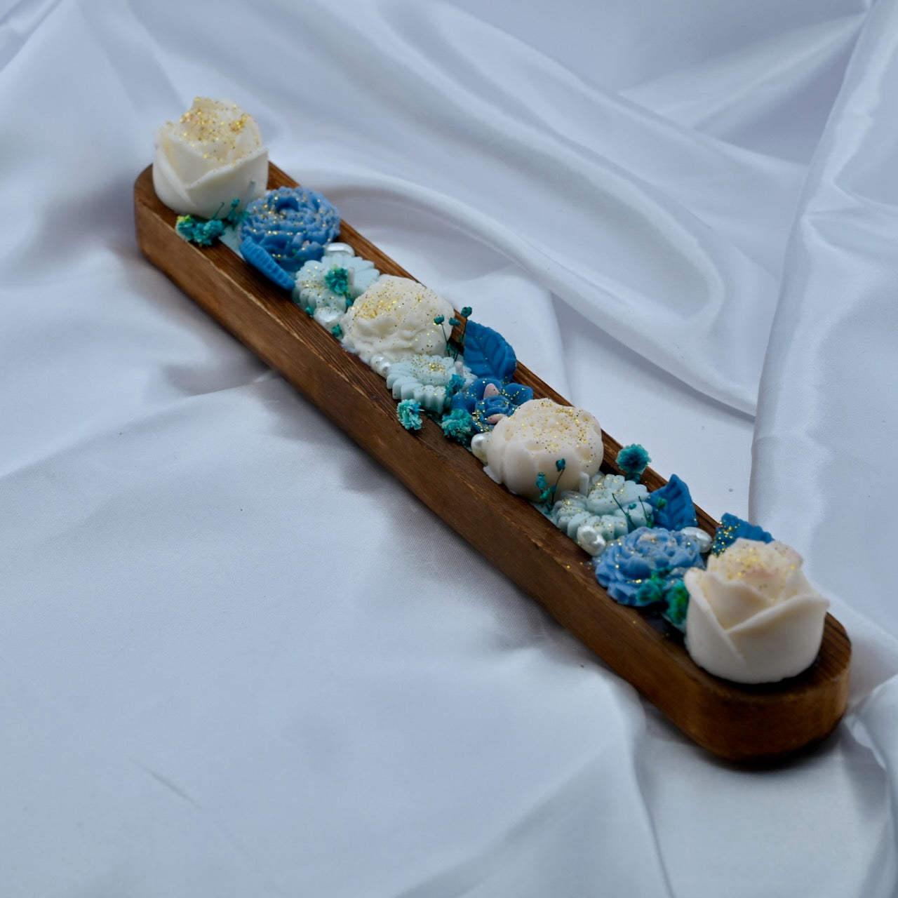 Left view of wooden bowl candle with blue and white floral wax design