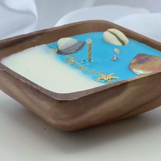 Video of  square acacia wood bowl candle with seashell and starfish wax details
