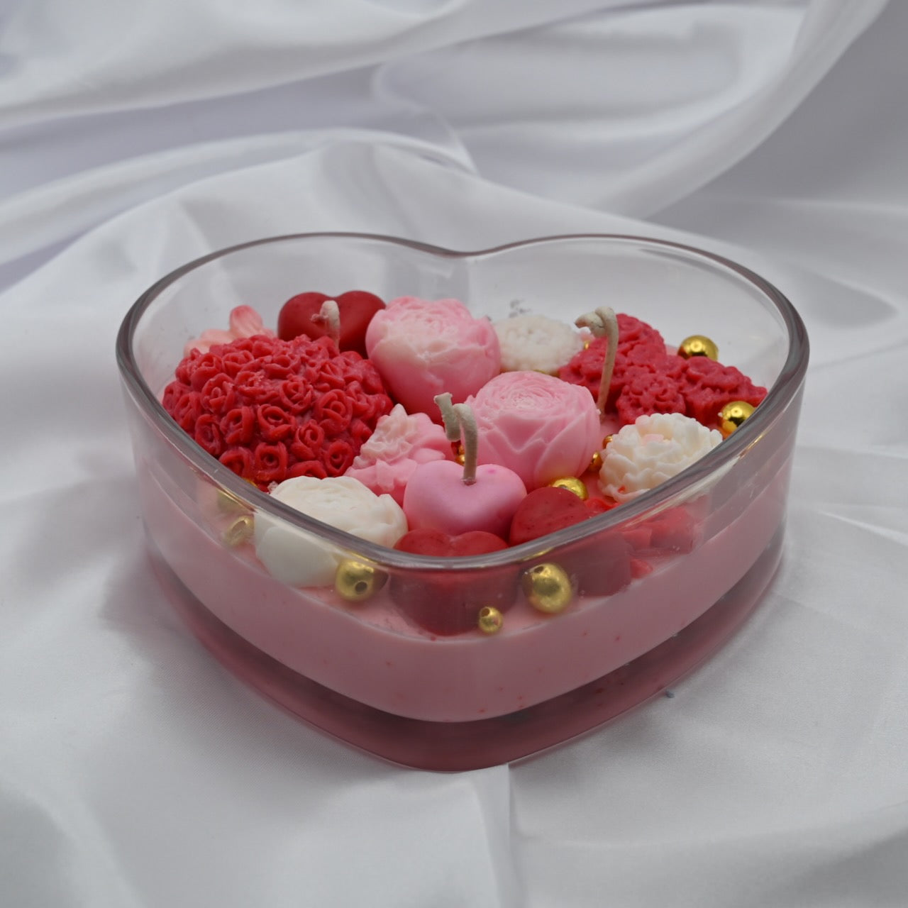 Close up view of hand-poured  rose soy candle in heart-shaped glass container from RG Candleline.