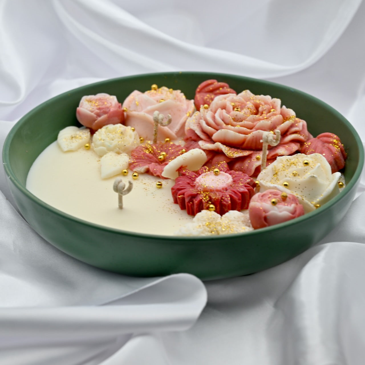 Right view of green bowl candle with pink and blush floral wax design and gold accents