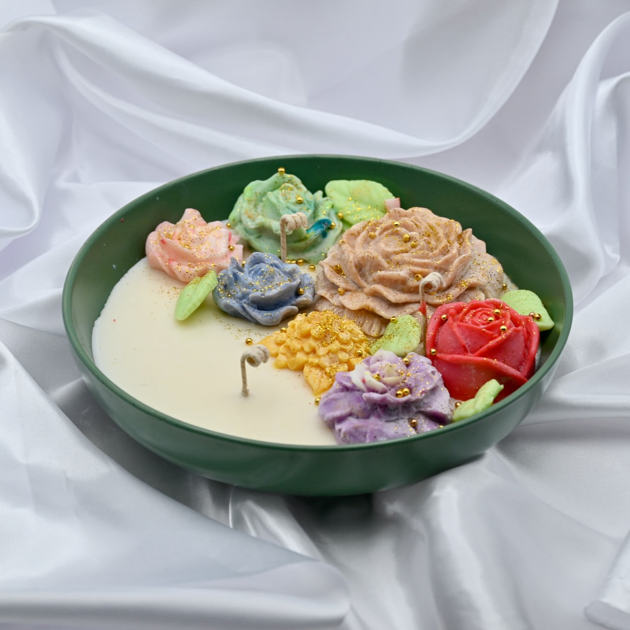 Right view of green bowl candle with multicolor floral wax design and gold accents