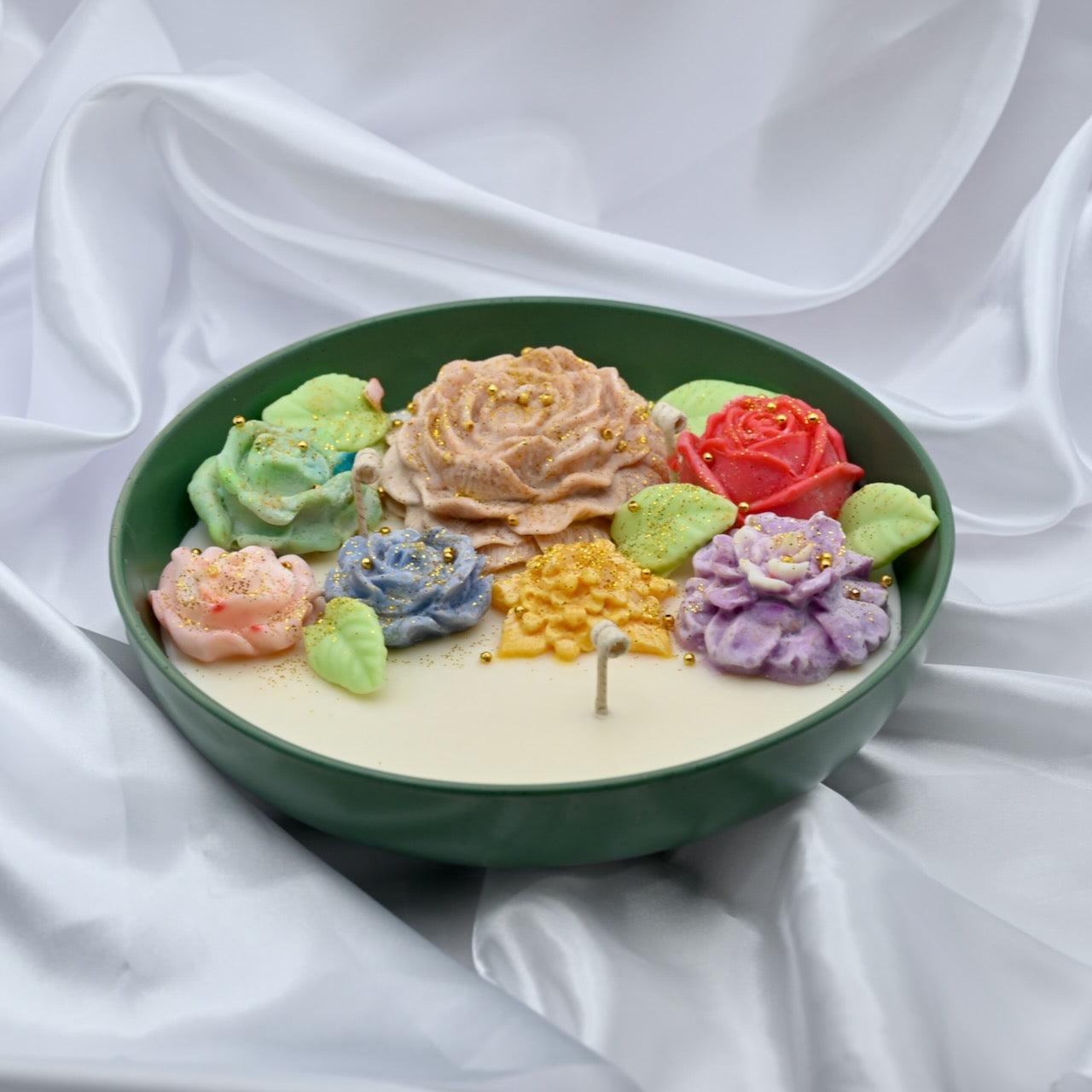 Green bowl candle with multicolor floral wax design and gold accents